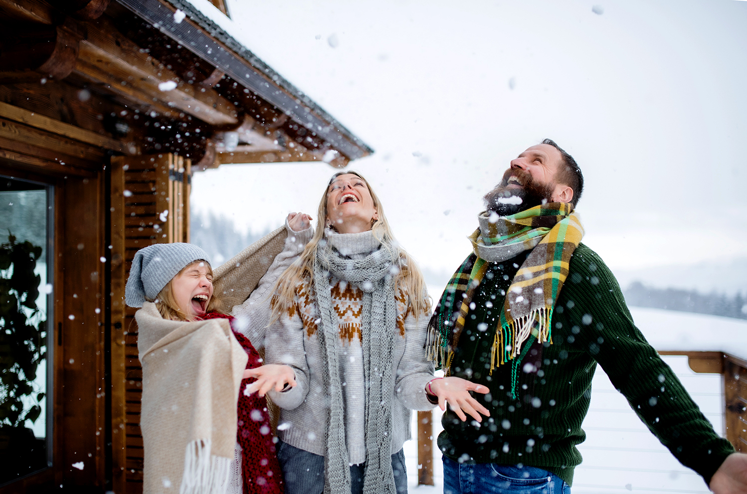 Happy family with small daughter having fun on terrace outdoors, holiday in winter nature.