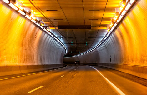 Highway road near Glenwood Springs Canyon in Colorado with long exposure of light inside tunnel with orange color and car.