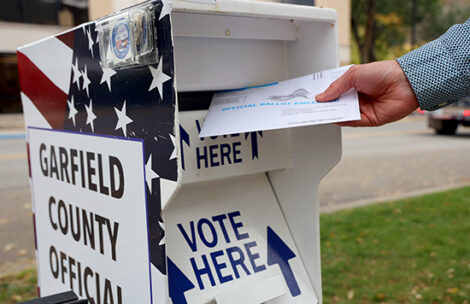 A voter drops a completed mail ballot into an official Garfield County drop box in Glenwood Springs, Colorado.