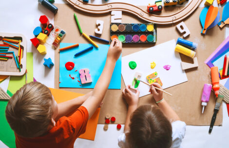 Children drawing and making crafts in kindergarten or daycare.