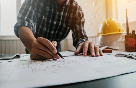 Architect or engineer working at home drawing the construction project.
