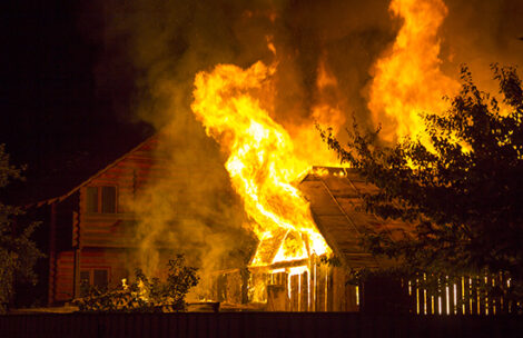 Burning wooden house at night.