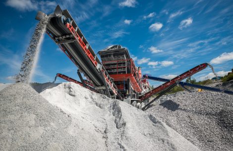 An excavator digs in a gravel pit.