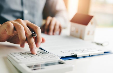 Home agents are using a calculator to calculate the loan period each month for the customer.