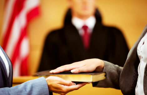 Witness swearing on the Bible telling the truth in the court room.