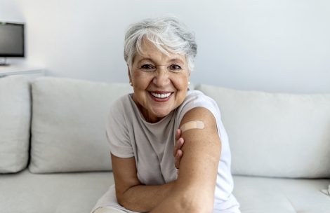 Portrait of a senior woman proudly showing her arm with bandage after getting vaccine.