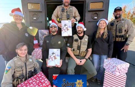 Garfield County Sheriff's Office deputies are seen in front of the Bearcat holding wrapped presents for the annual Shop With a Cop" event.