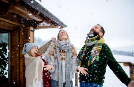 Happy family with small daughter having fun on terrace outdoors, holiday in winter nature.