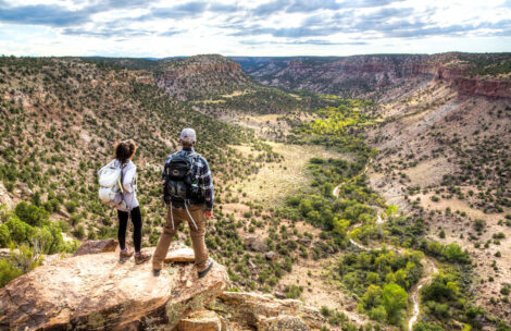 Two hikers peer over the the Dominguez–Escalante National Conservation Area near Grand Junction, CO.