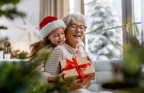 Granny and little child having fun near tree indoors.