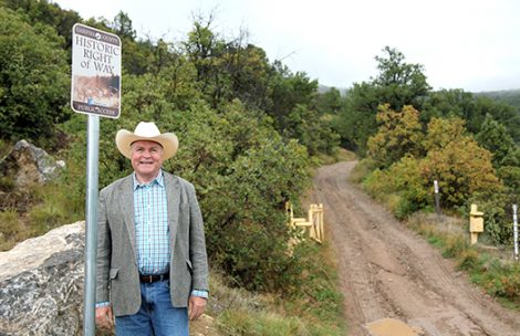 Garfield County Commissioner Tom Jankovsky standing next to a historic right of way sign.