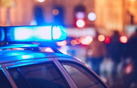 Blue flasher on the police car at night.