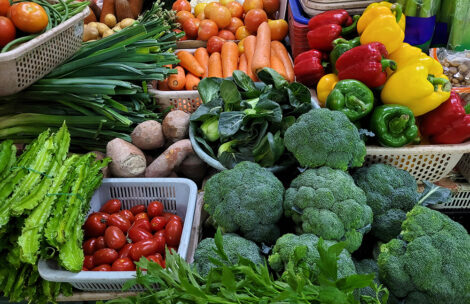 Fresh vegetables and fruits for sale at a farmer market stall.