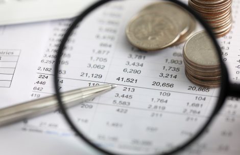 View at financial details in table thru magnifying glass close-up