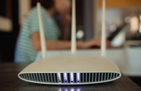 A woman is working at home using a modem router, connecting the Internet to her laptop.