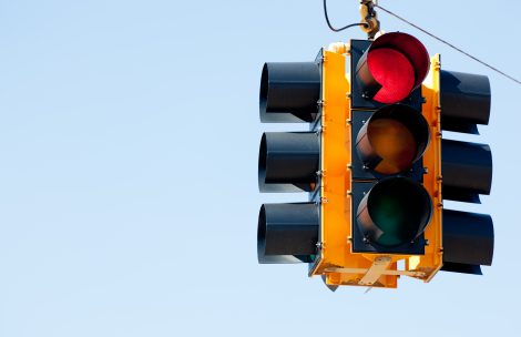 A red light traffic signal with blue sky copy space