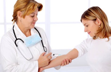 Female doctor giving an injection to the patient during visit at the hospital's chamber.